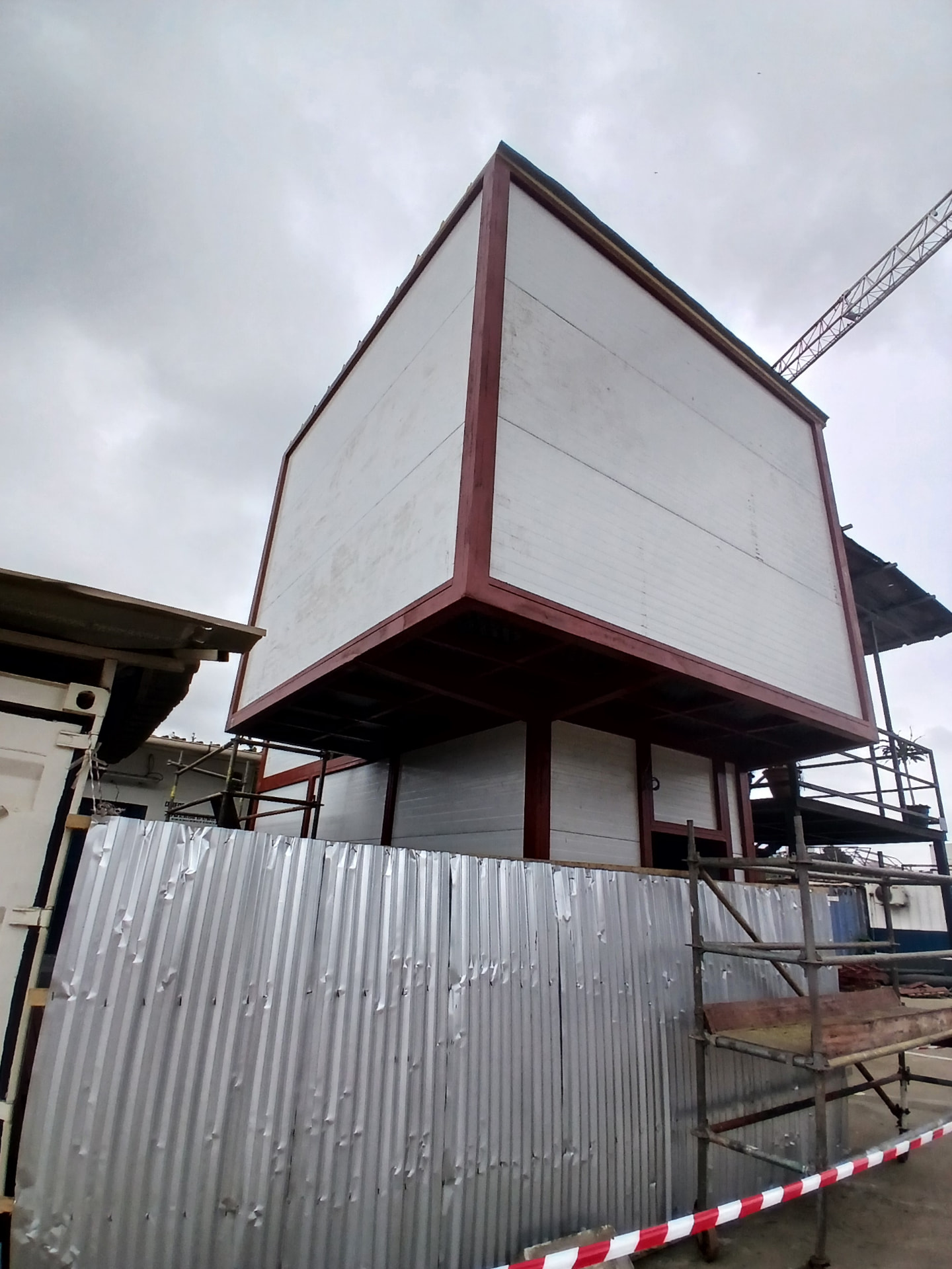 Bureaux préfabriqués R+1 à Abidjan Carena : structure métallique, panneaux sandwichs et bardage blanc en cours de finition — vue 1