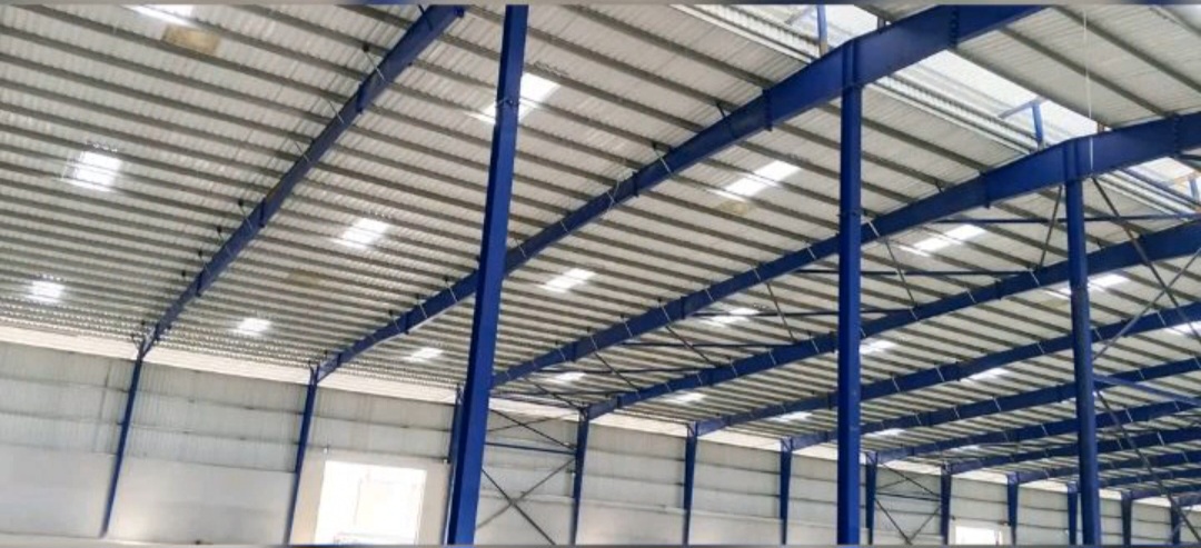 Charpente industrielle 20 000 m² à Yopougon PK24 : structure métallique bleue, pannes, portiques et couverture en cours de finition — vue 6