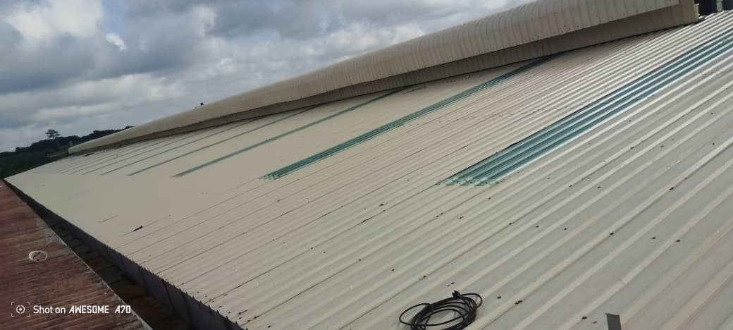 Charpente industrielle agroalimentaire 5 001 m² à Bonoua : bardage beige, structure métallique, couverture et montage en cours — vue 4