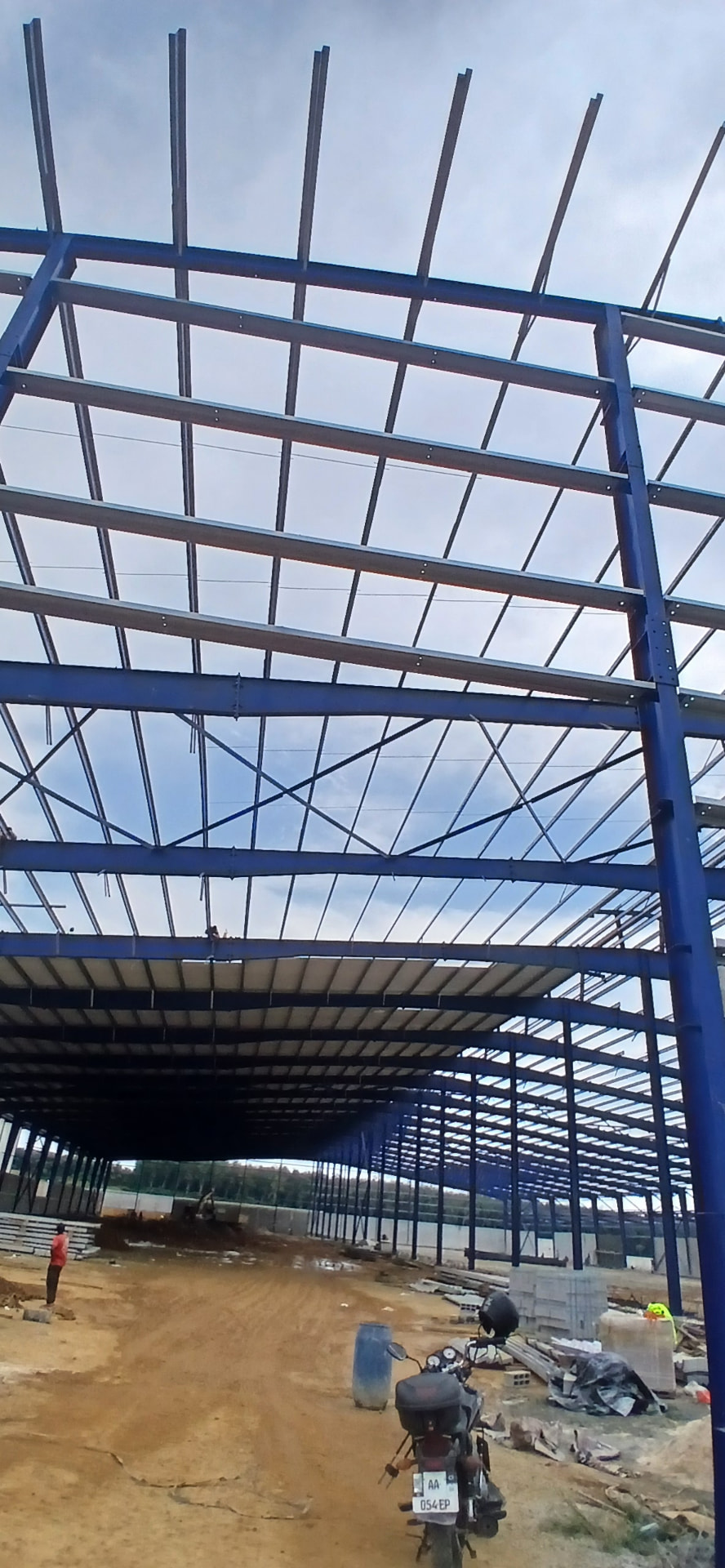 Charpente industrielle 20 000 m² à Yopougon PK24 : structure métallique bleue, pannes, portiques et couverture en cours de finition — vue 7